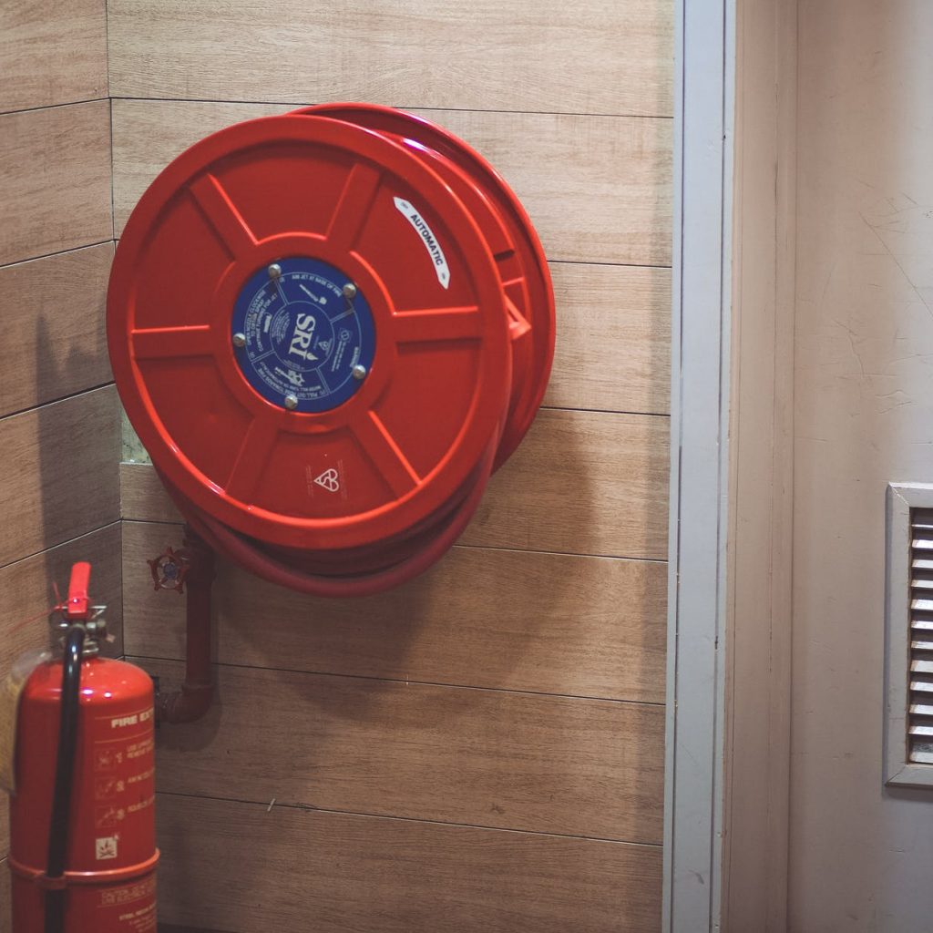 red fire extinguisher below hose reel