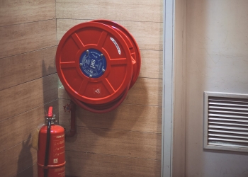 red fire extinguisher below hose reel