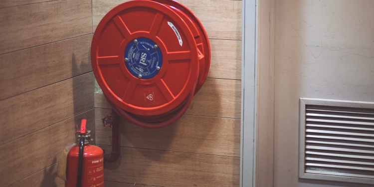 red fire extinguisher below hose reel