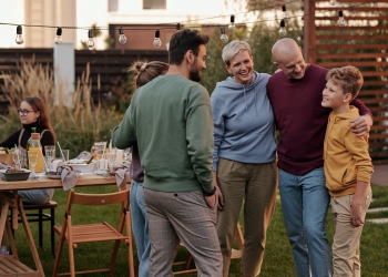 man in red sweater standing beside man in gray sweater