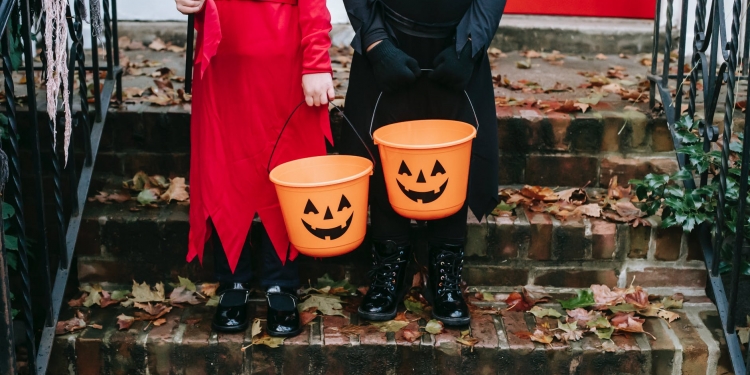 children holding a halloween design buckets
