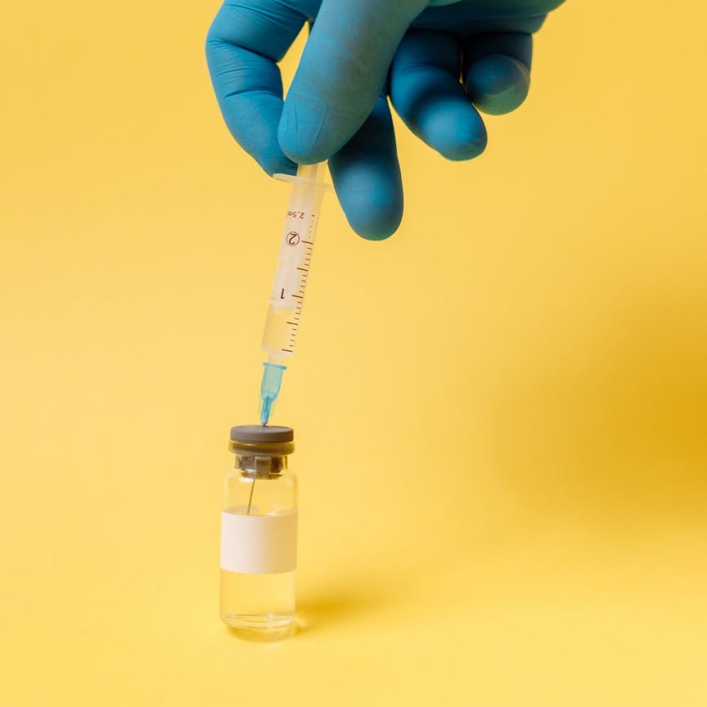 covid vaccine on yellow surface