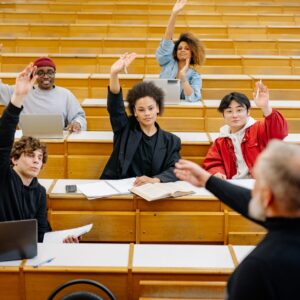students raising their hands in a classroom