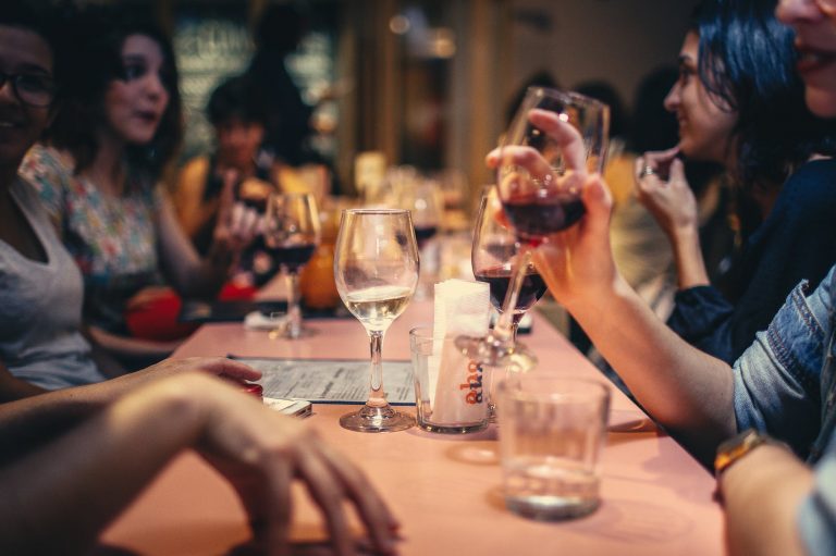 people drinking liquor and talking on dining table close up photo