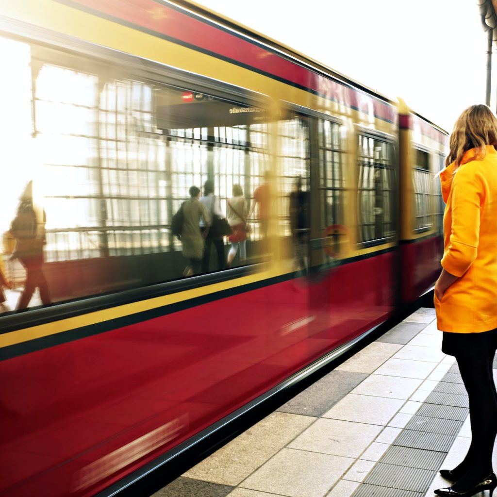 woman standing beside red train