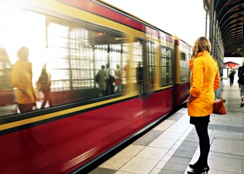 woman standing beside red train