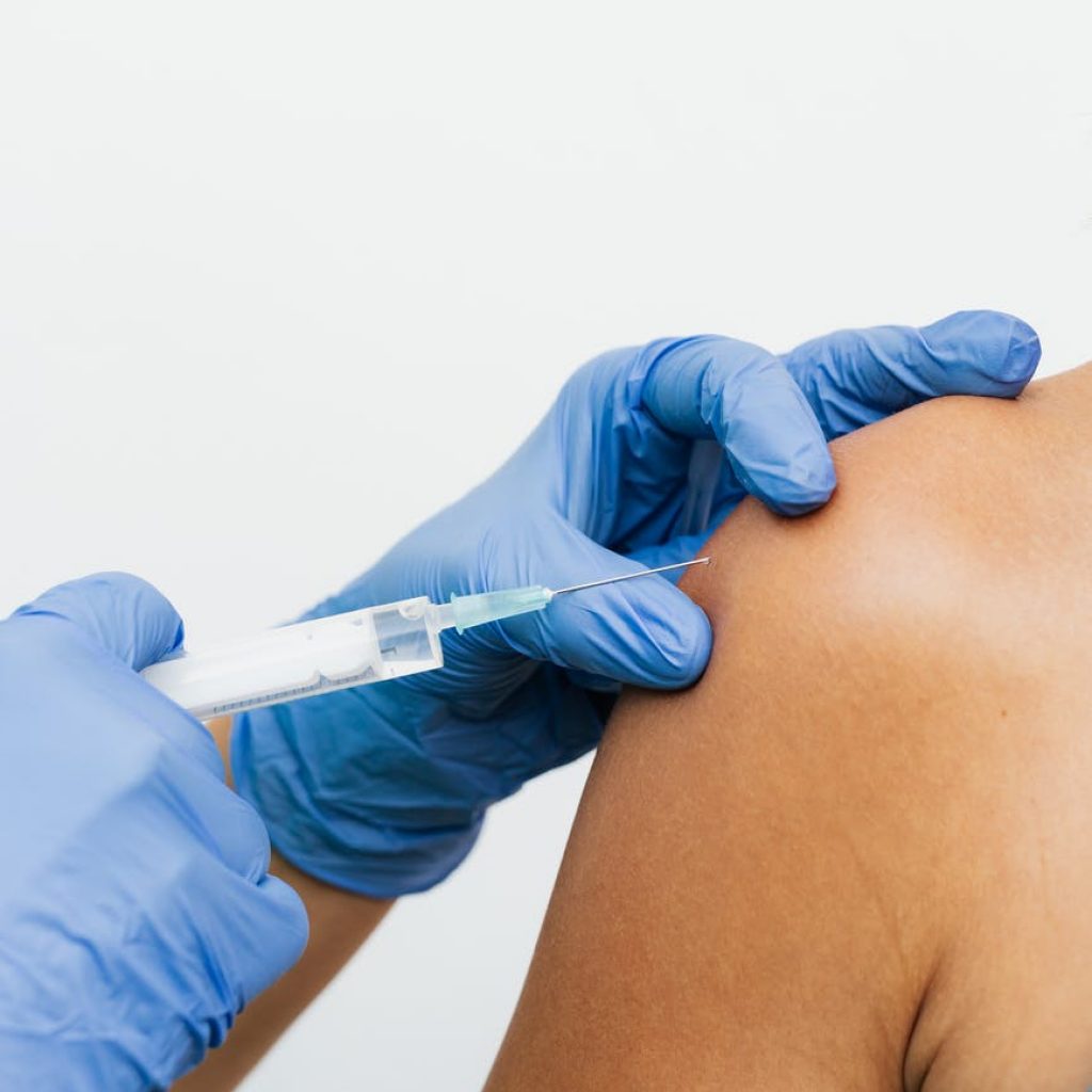 person wearing gloves holding a syringe