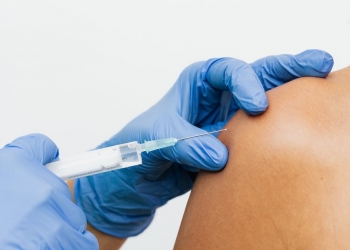 person wearing gloves holding a syringe