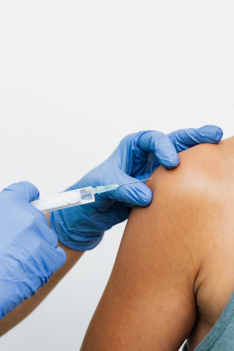 person wearing gloves holding a syringe
