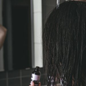 woman putting a product on her hair