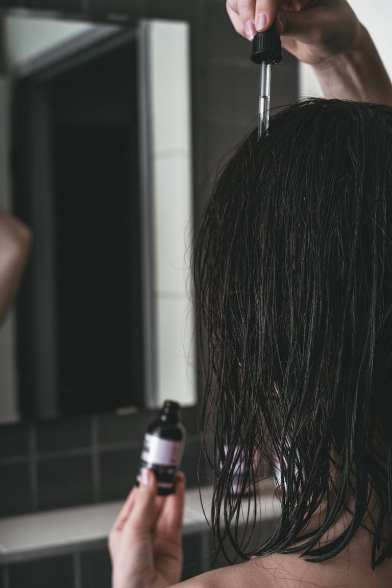 woman putting a product on her hair
