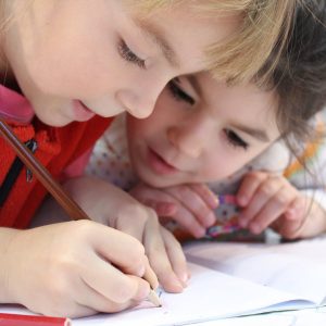 girls on desk looking at notebook