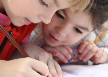girls on desk looking at notebook