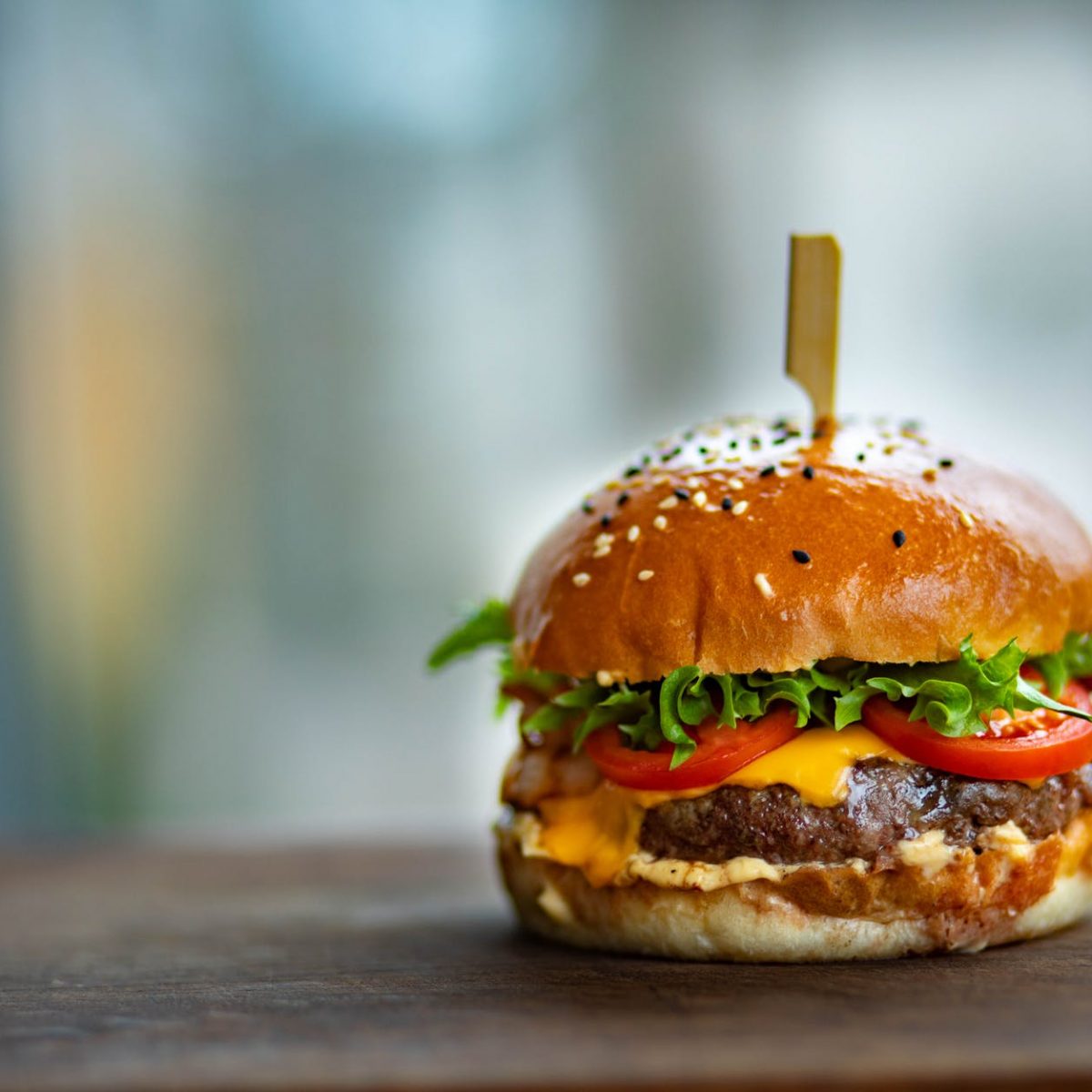 photo of juicy burger on wooden surface