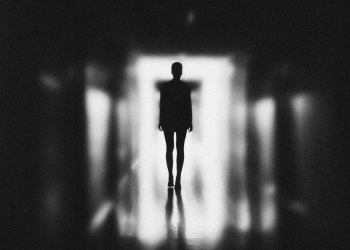 monochrome photo of person standing on hallway