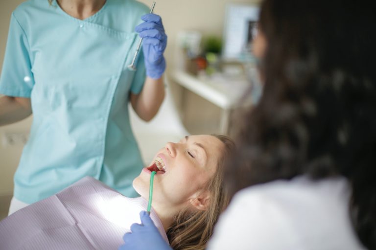 unrecognizable female dentist with assistant preparing for inspecting patient teeth
