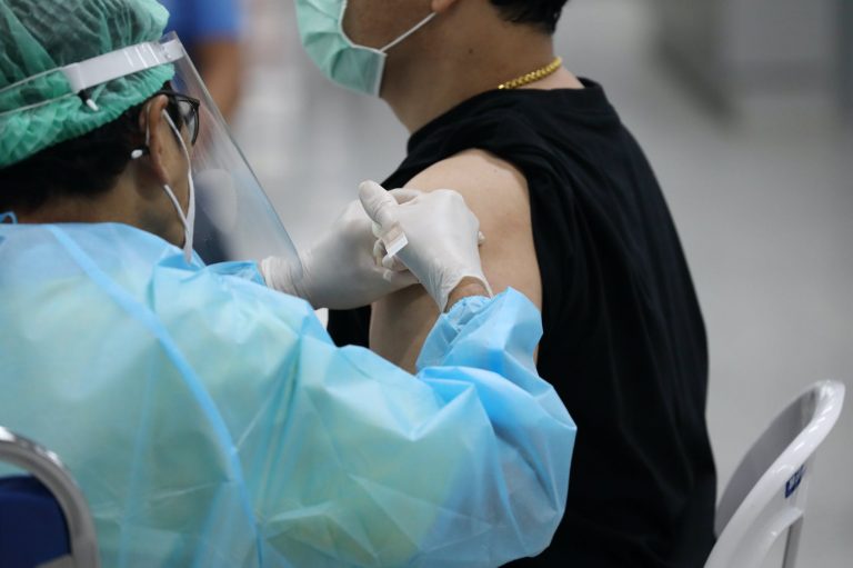 man in black shirt getting vaccinated