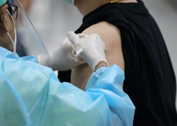 man in black shirt getting vaccinated