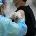 man in black shirt getting vaccinated
