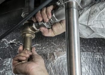 plumber installs pipe fittings