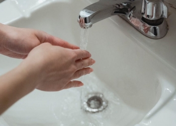 person washing hands on washbasin