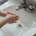 person washing hands on washbasin