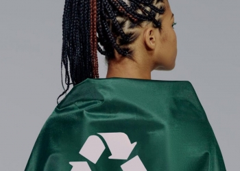 a back view of a woman in green cape