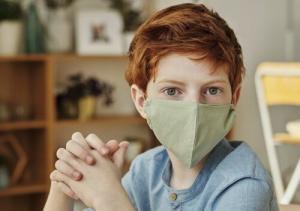 Red headed boy wearing green mask