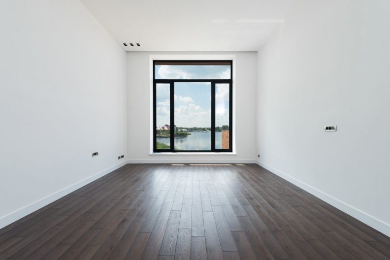 spacious room with white walls and panoramic windows