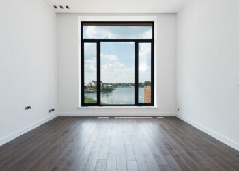 spacious room with white walls and panoramic windows