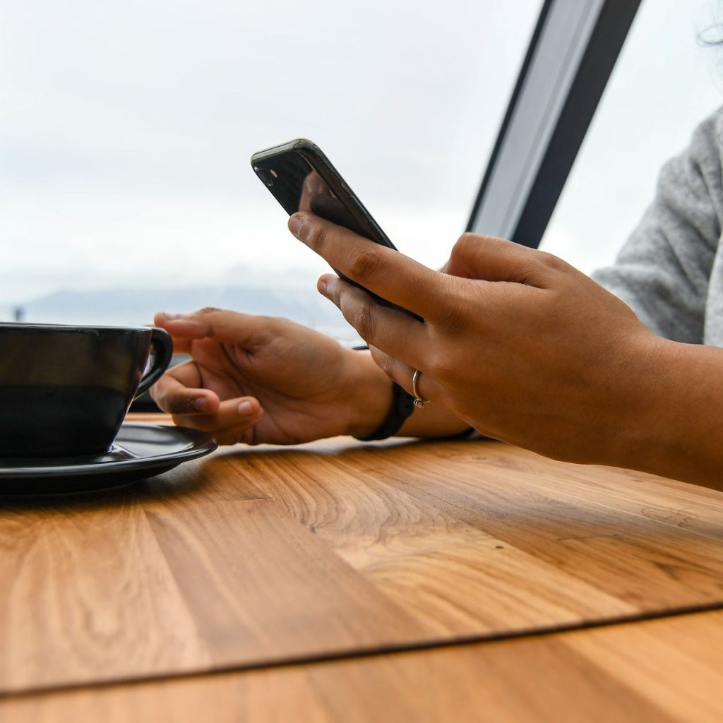 person holding ceramic cup on table