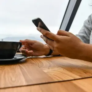 person holding ceramic cup on table