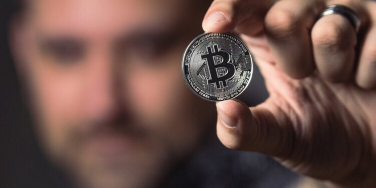person holding silver bitcoin coin