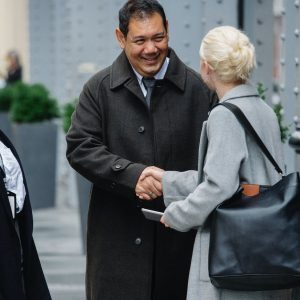 positive ethnic colleagues greeting anonymous female partner on street