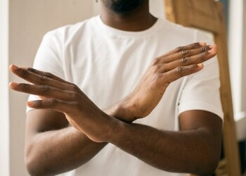 faceless black man showing stop gesture with crossed hands