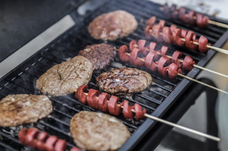 steaks and skewered sausages on grill