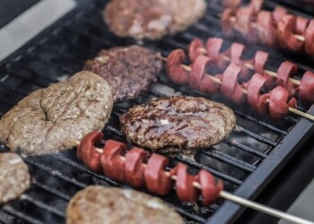 steaks and skewered sausages on grill