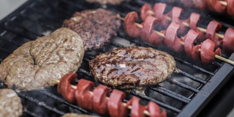 steaks and skewered sausages on grill