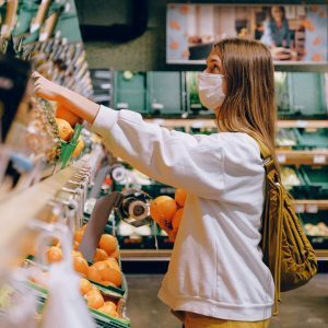 woman in white long sleeve jacket shopping for fruits