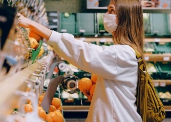woman in white long sleeve jacket shopping for fruits