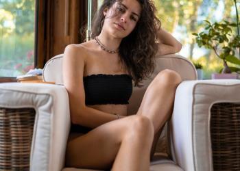 woman with wavy hair resting in cozy armchair