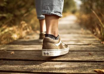 person stands on brown pathway