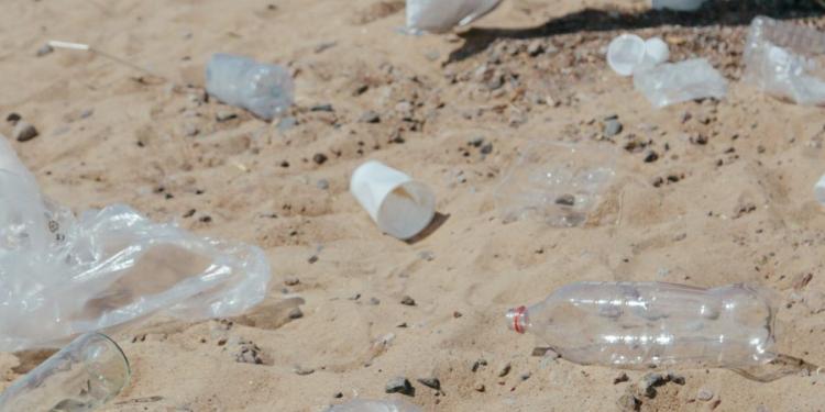 plastic bottles and plastic bags on sand