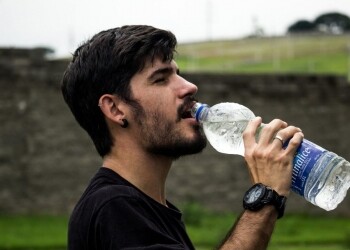 man wearing black shirt drinking water