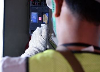 a man working on an electric switch breakers