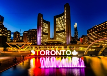 powered on toronto neon sign near water fountain