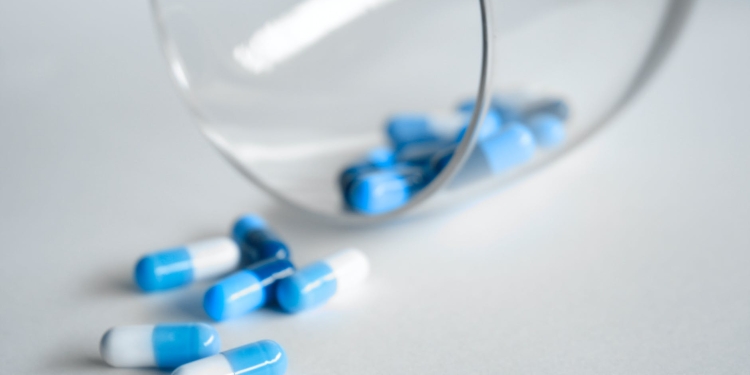 depth photography of blue and white medication pill