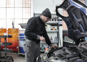 photo of man inspecting car engine