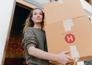young woman with boxes while moving out of old home