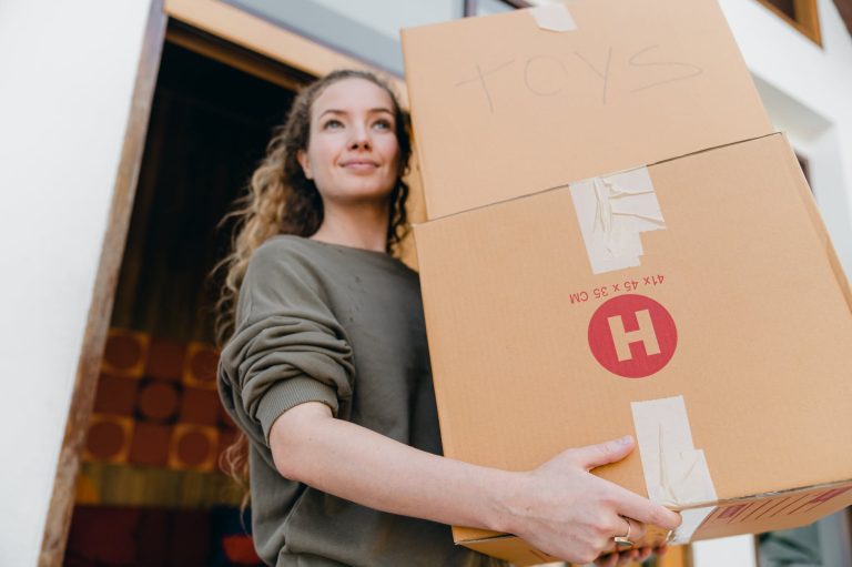 young woman with boxes while moving out of old home